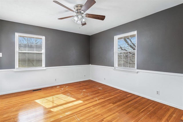 empty room with hardwood / wood-style floors and ceiling fan