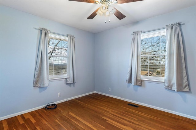 empty room featuring dark wood-type flooring and ceiling fan