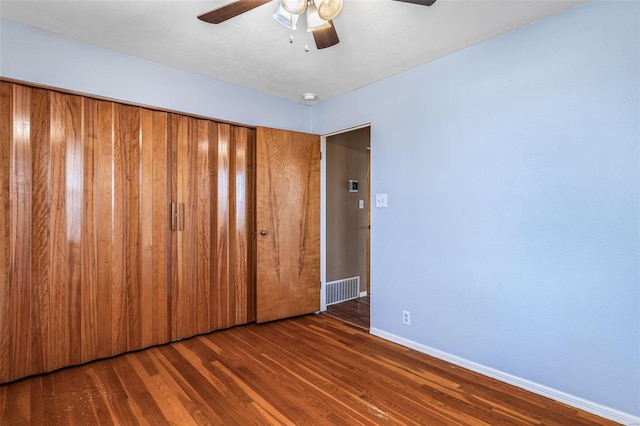 spare room featuring dark wood-type flooring and ceiling fan