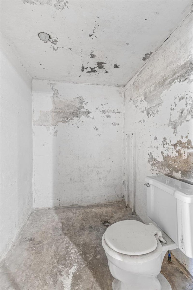 bathroom with concrete flooring and toilet