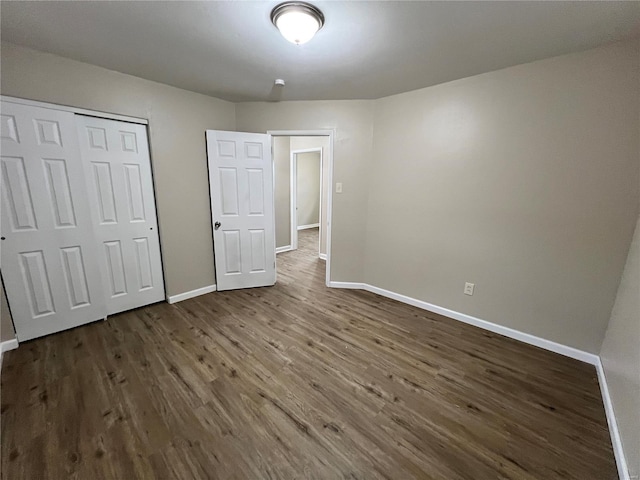 unfurnished bedroom featuring dark wood-type flooring and a closet