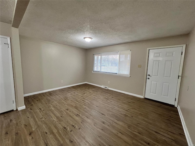 entryway with dark wood-type flooring and a textured ceiling