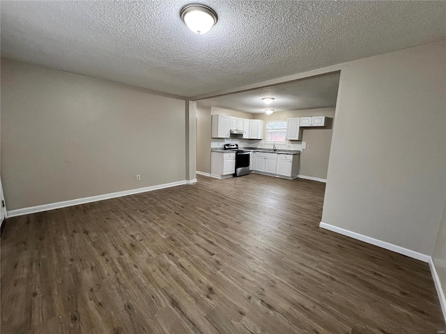 unfurnished living room with dark wood-type flooring, sink, and a textured ceiling