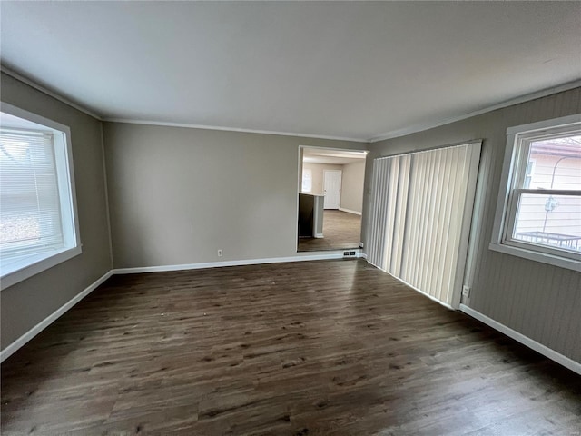 empty room featuring ornamental molding and dark hardwood / wood-style floors