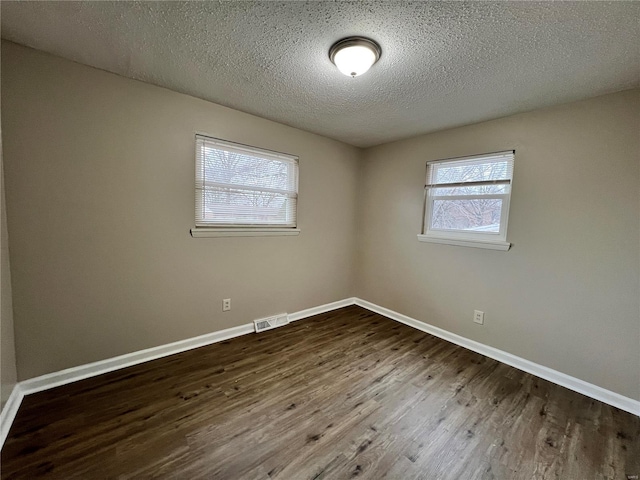 spare room with hardwood / wood-style floors and a textured ceiling