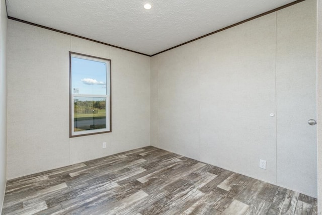 spare room with a textured ceiling and hardwood / wood-style flooring