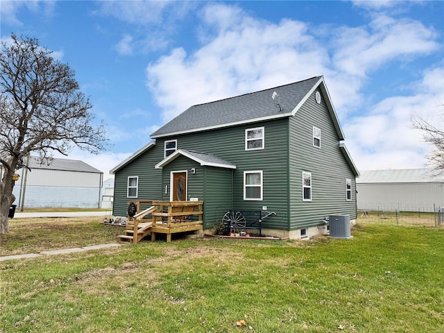 rear view of property with a deck, a lawn, and central AC