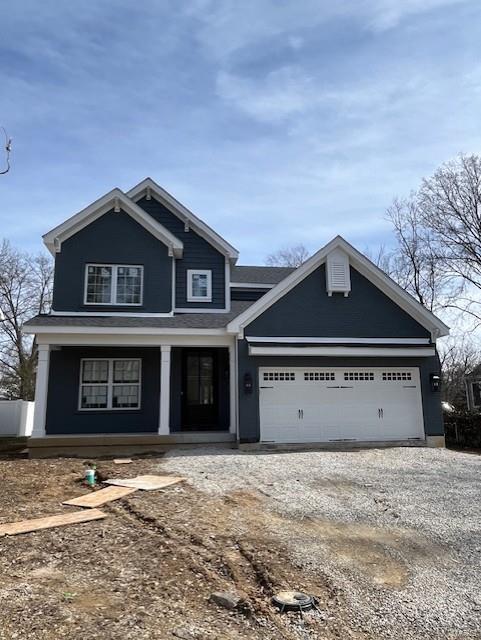 view of front of house featuring covered porch, driveway, and an attached garage