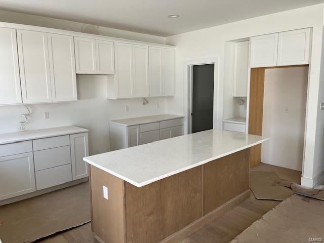 kitchen with white cabinets, light wood-style floors, and a center island