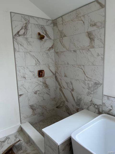 bathroom with tiled shower, marble finish floor, a freestanding bath, and lofted ceiling