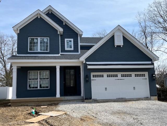 view of front of property featuring a porch, a garage, and driveway