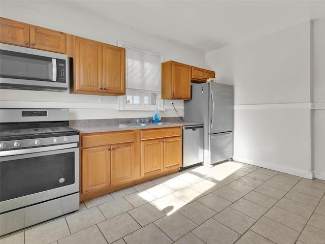 kitchen featuring stainless steel appliances, light tile patterned floors, and sink