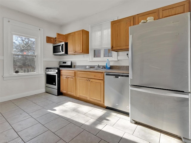 kitchen featuring appliances with stainless steel finishes, sink, and light tile patterned floors