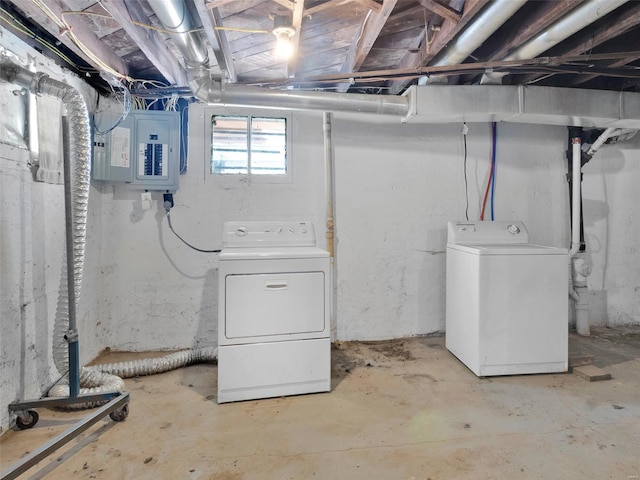 basement with electric panel and washing machine and clothes dryer