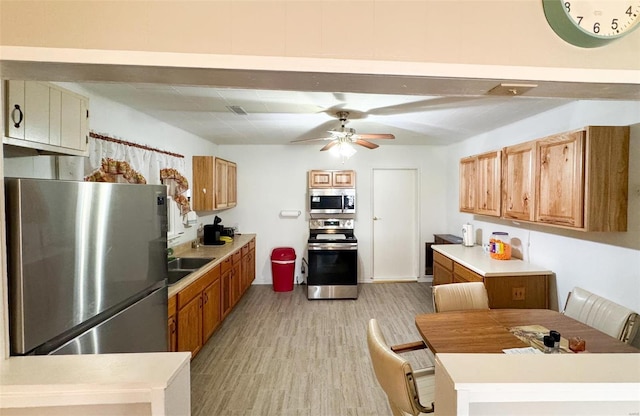 kitchen featuring ceiling fan, light wood-type flooring, and stainless steel appliances