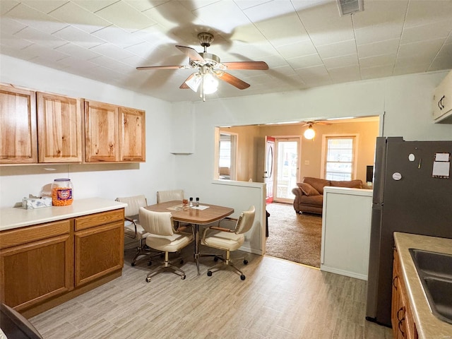 dining room with ceiling fan and light hardwood / wood-style flooring