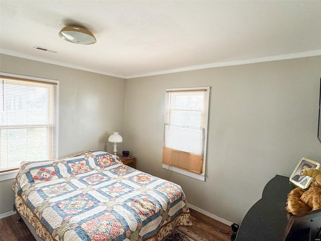 bedroom featuring crown molding and dark wood-type flooring