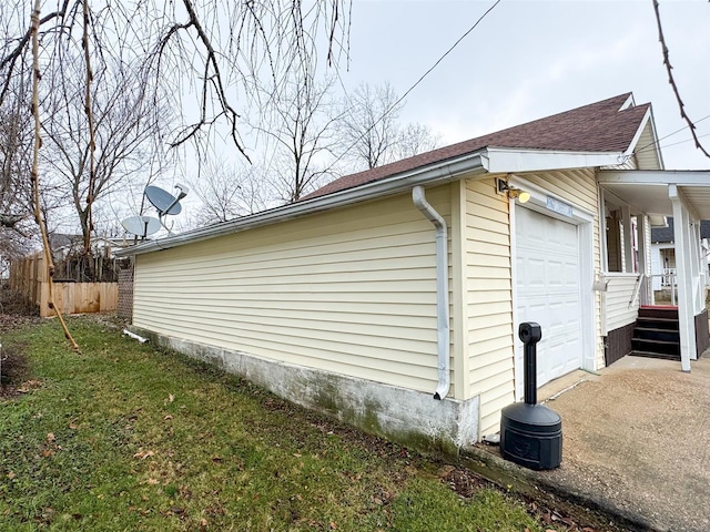 view of side of home with a garage and a lawn