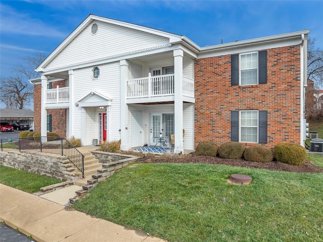 view of front of property with a front yard and a balcony