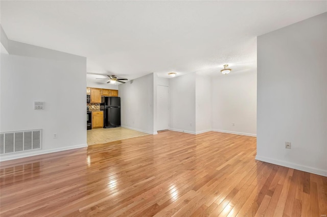 unfurnished living room with ceiling fan and light wood-type flooring