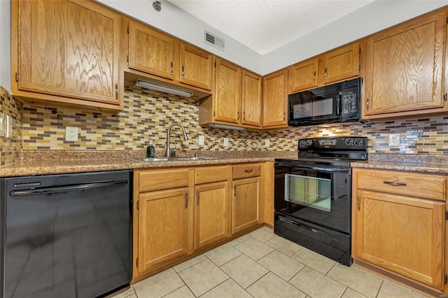 kitchen with tasteful backsplash, dark stone counters, sink, and black appliances