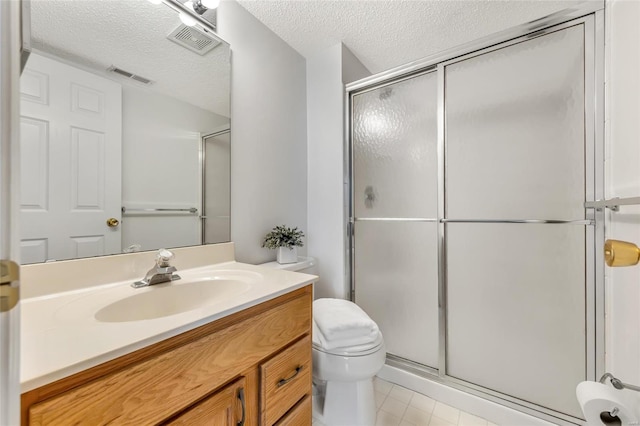 bathroom featuring a shower with door, vanity, a textured ceiling, and toilet