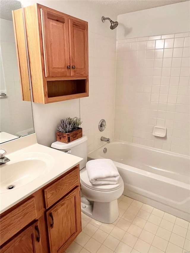 full bathroom with tiled shower / bath, vanity, toilet, tile patterned floors, and a textured ceiling