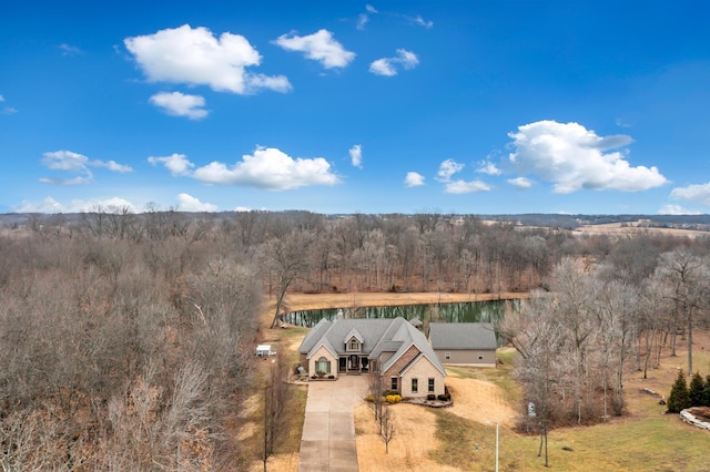 birds eye view of property featuring a water view and a view of trees