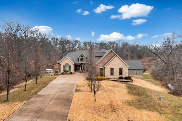 view of front of home featuring a chimney, concrete driveway, and a front yard