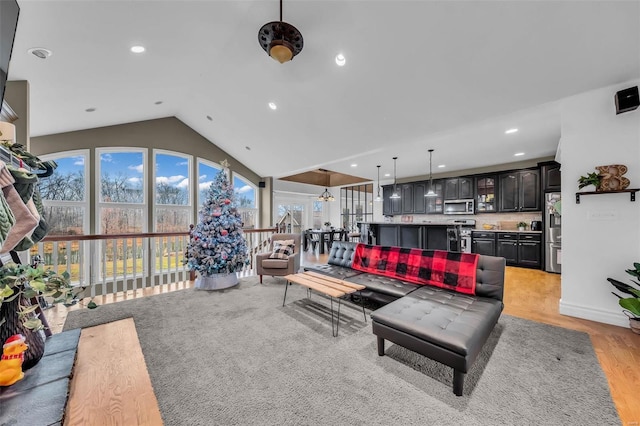 living area with vaulted ceiling, light wood-type flooring, and recessed lighting