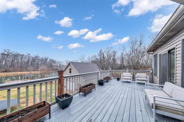 wooden deck featuring an outdoor living space with a fire pit and a water view