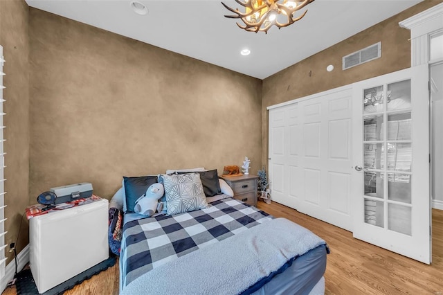 bedroom with recessed lighting, visible vents, light wood finished floors, and an inviting chandelier