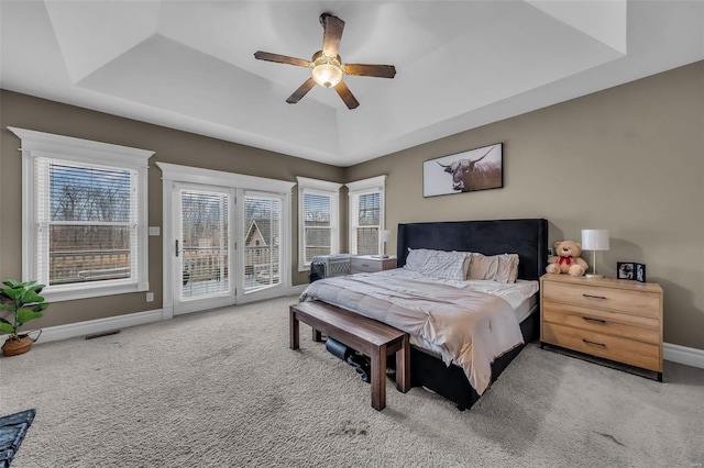 bedroom featuring carpet floors, visible vents, baseboards, access to outside, and a raised ceiling