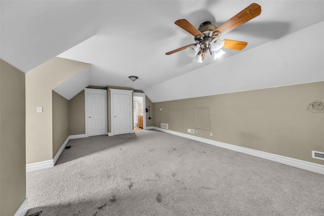 additional living space featuring carpet floors, visible vents, baseboards, and vaulted ceiling