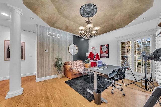 office space featuring visible vents, decorative columns, baseboards, and wood finished floors