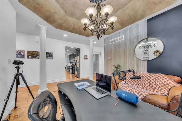 office space featuring visible vents, light wood-type flooring, decorative columns, and baseboards