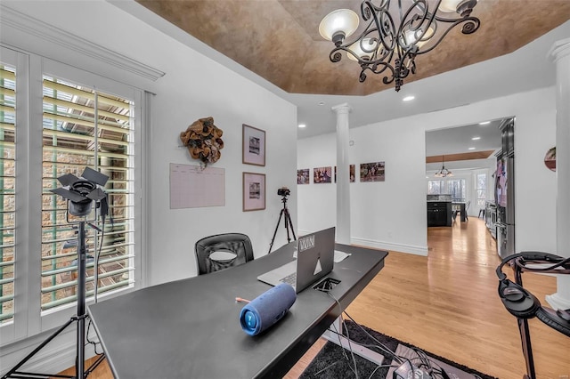 office area featuring baseboards, wood finished floors, decorative columns, and a notable chandelier