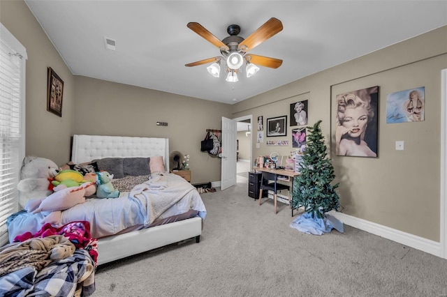 carpeted bedroom featuring a ceiling fan, visible vents, and baseboards