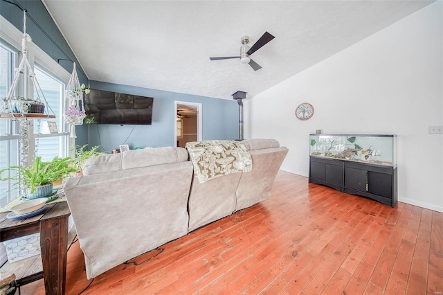 living room featuring ceiling fan, vaulted ceiling, and wood-type flooring