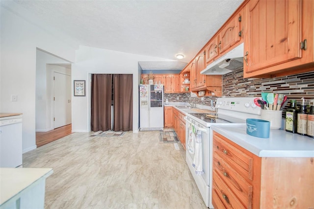 kitchen featuring sink, white appliances, decorative backsplash, and lofted ceiling