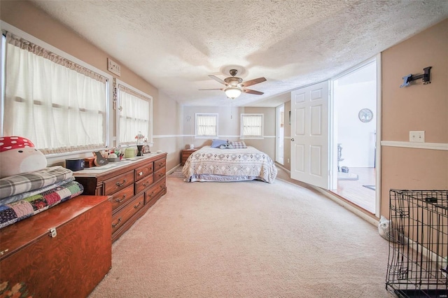 carpeted bedroom featuring a textured ceiling and ceiling fan