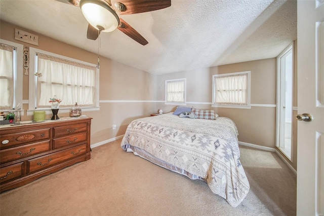 carpeted bedroom with a textured ceiling and ceiling fan