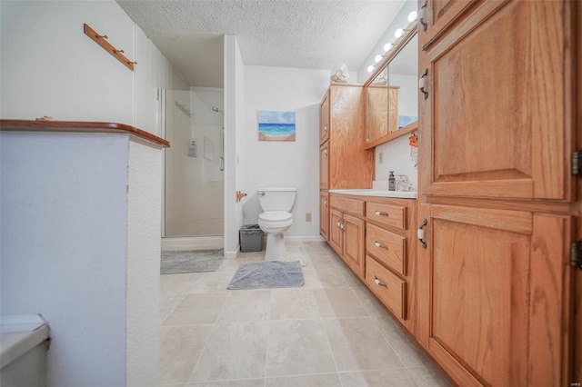 bathroom with toilet, a textured ceiling, a shower with door, tile patterned floors, and vanity