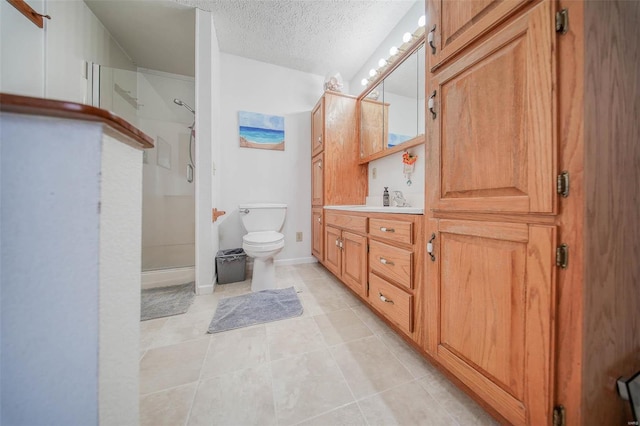 bathroom featuring tile patterned flooring, toilet, vanity, a textured ceiling, and an enclosed shower