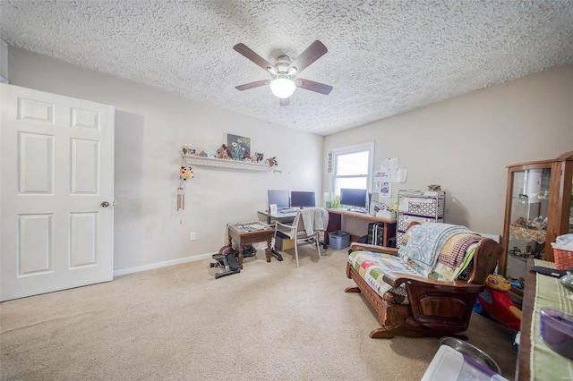 carpeted office featuring a textured ceiling and ceiling fan