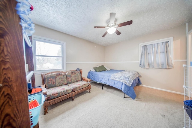 bedroom with a textured ceiling, carpet floors, and ceiling fan