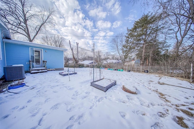 yard layered in snow featuring central air condition unit