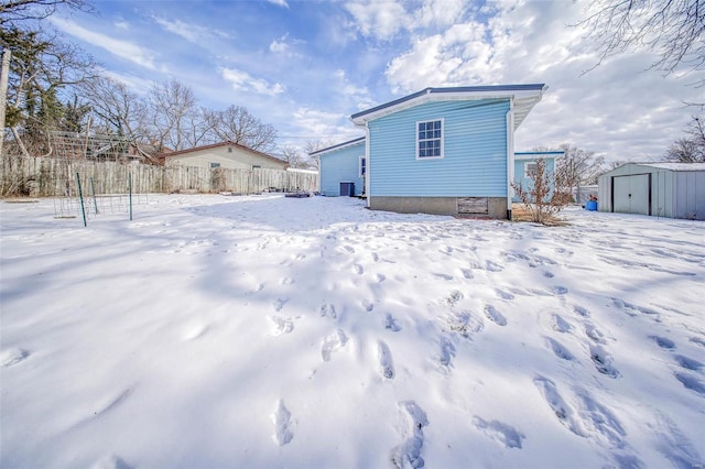 snow covered house with a storage unit