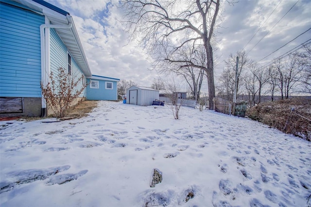 yard layered in snow with a storage shed