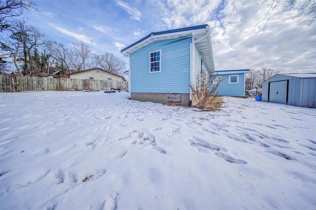 snow covered property featuring a storage unit